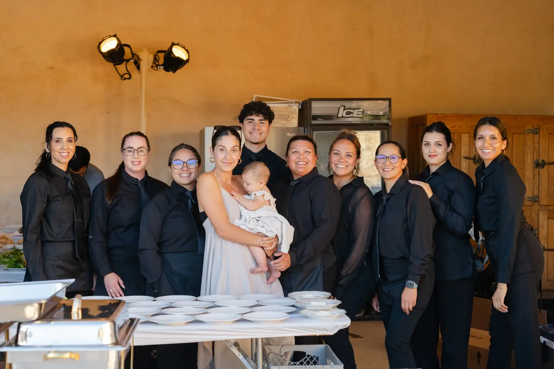 The All Purpose Flower crew before service at Sunstone Villa, gathered behind the service line, Golzar Meamar at center with her baby