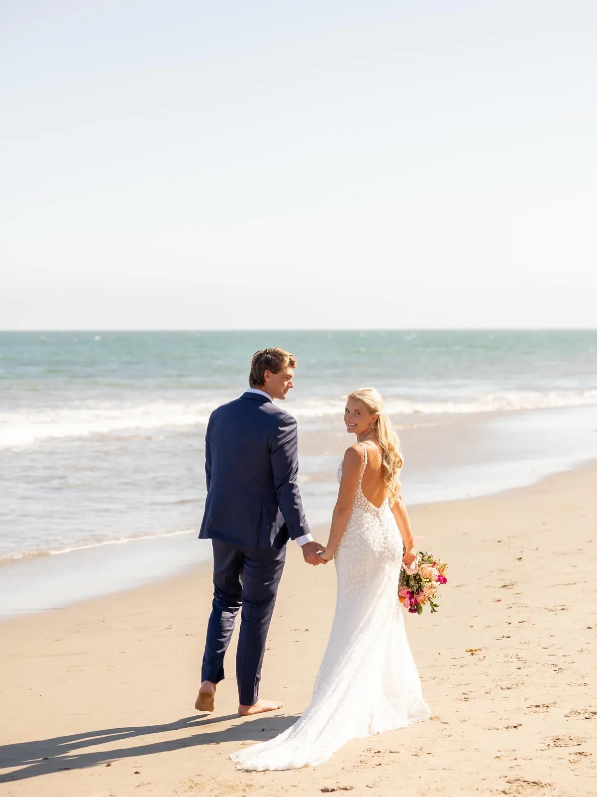 A couple on the beach at a coastal wedding