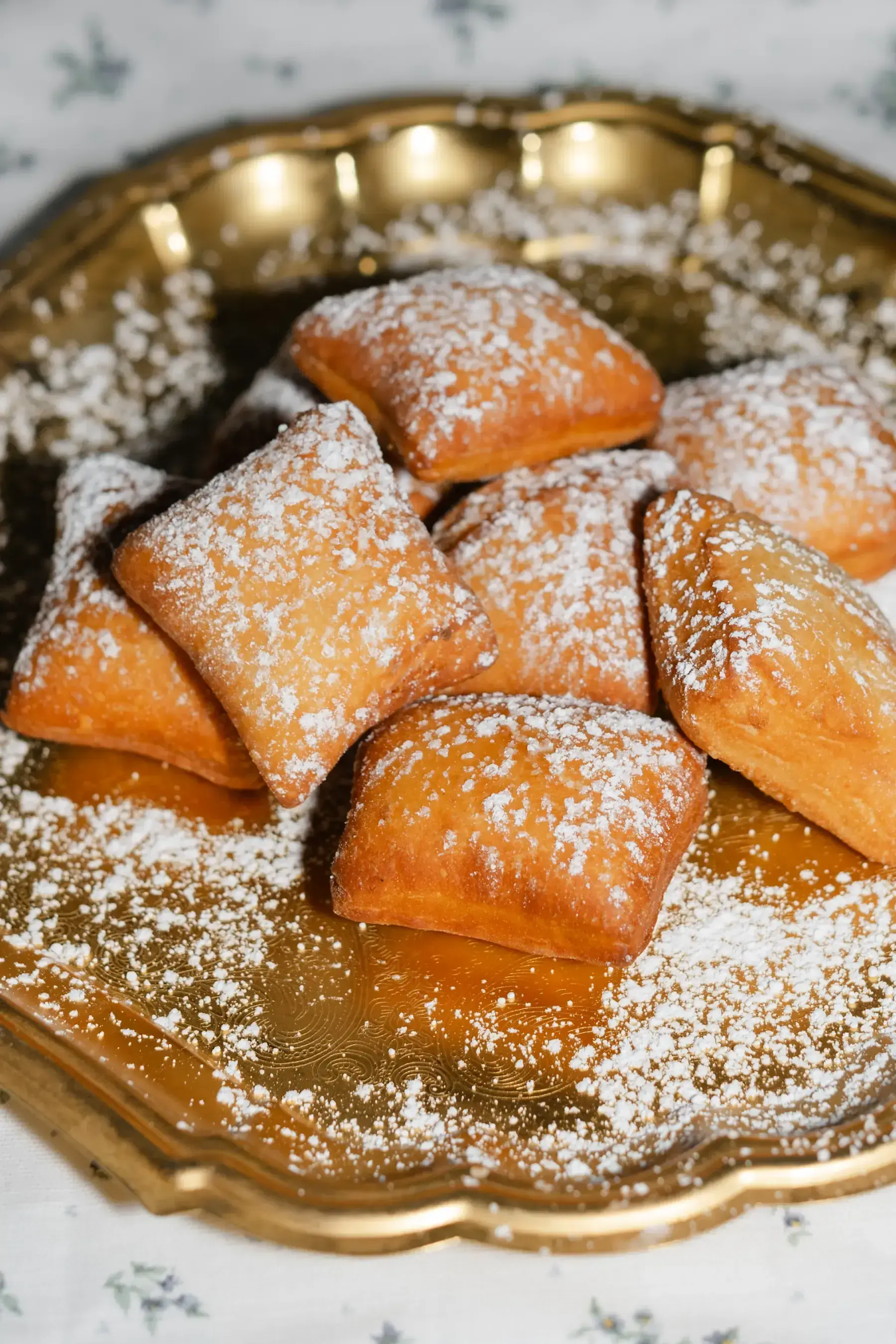 Beignets under powdered sugar on a scalloped gold tray, the stationed dessert at Heritage Square