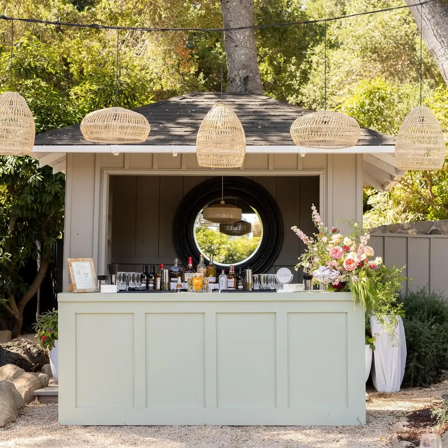 A styled All Purpose Flower outdoor bar with florals and glassware