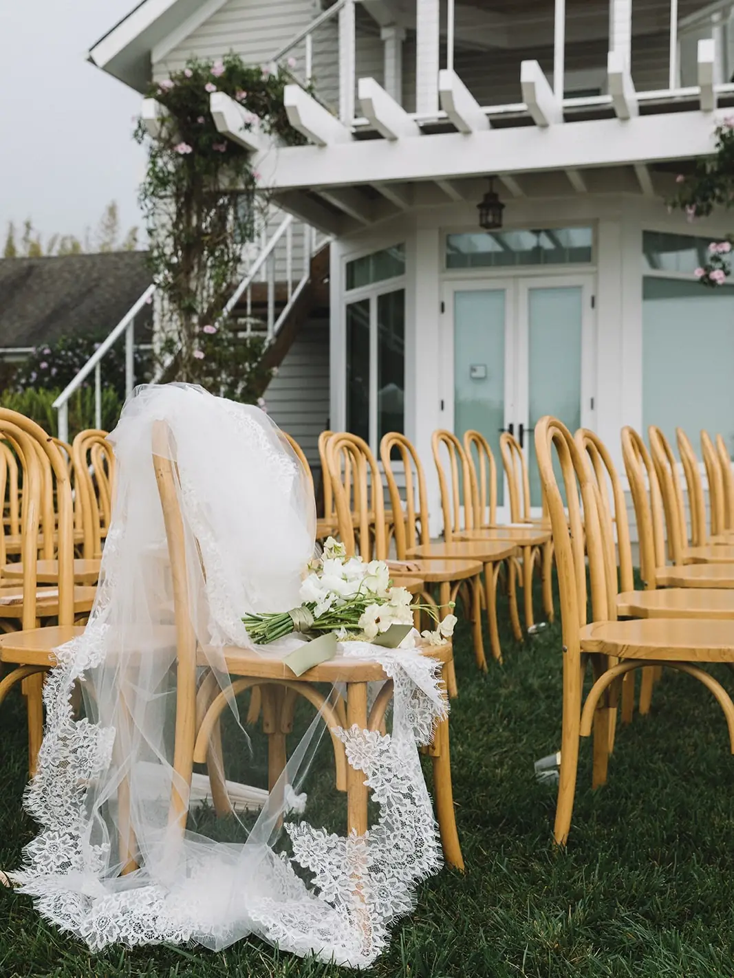 Ceremony chairs beside the white farmhouse at Regina Ranch
