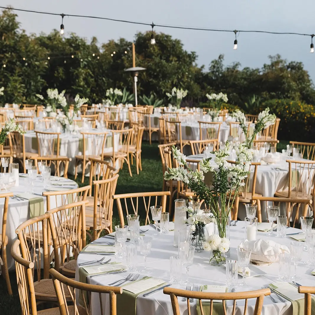 Reception tables set under string lights at Regina Ranch