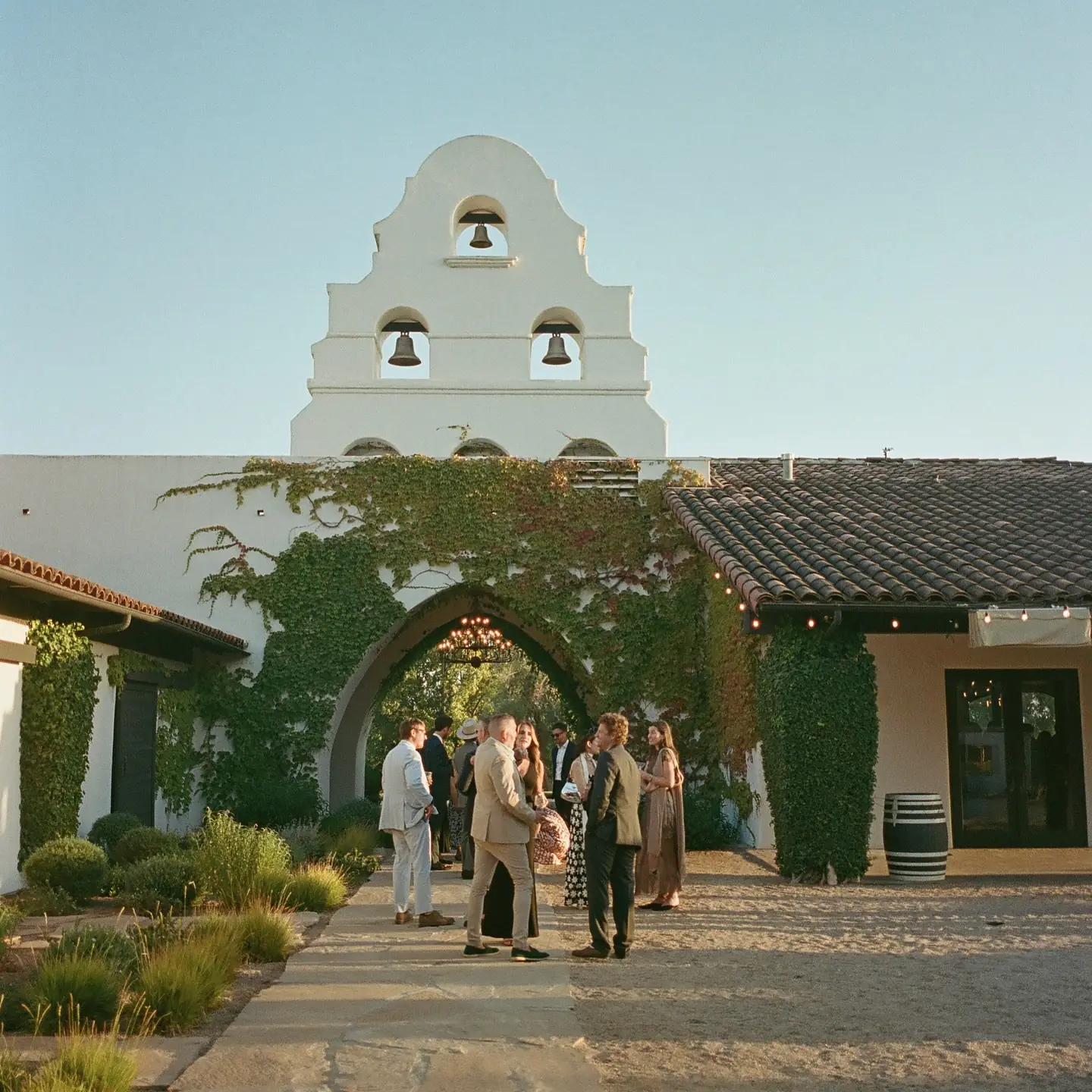 Guests by the mission-style arch and bell tower at Santa Ynez Ranch