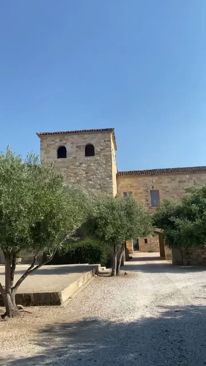 The stone tower and olive trees along the entry drive at Sunstone Villa