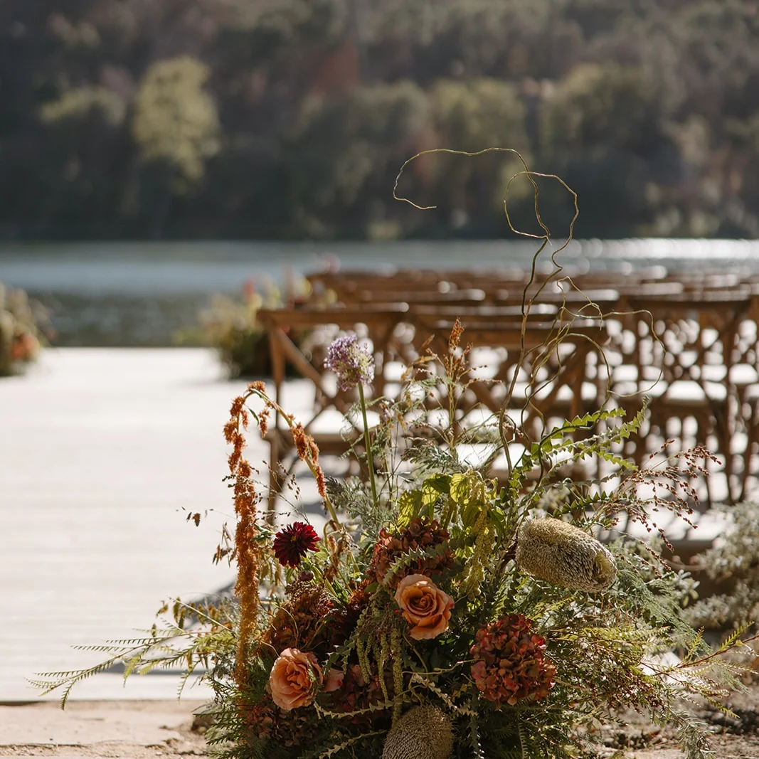 Rust and burgundy florals at the end of a row of chairs by the water at Zaca Lake
