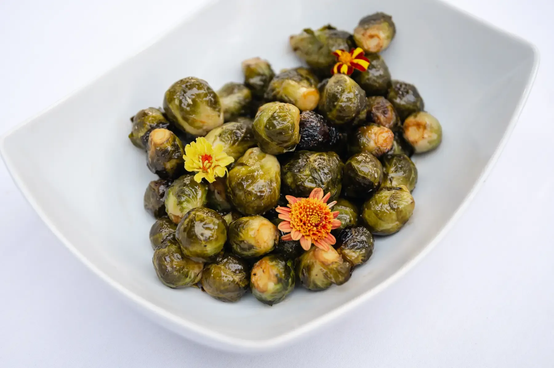 Roasted brussels sprouts scattered with marigold and zinnia petals, served at Zaca Lake