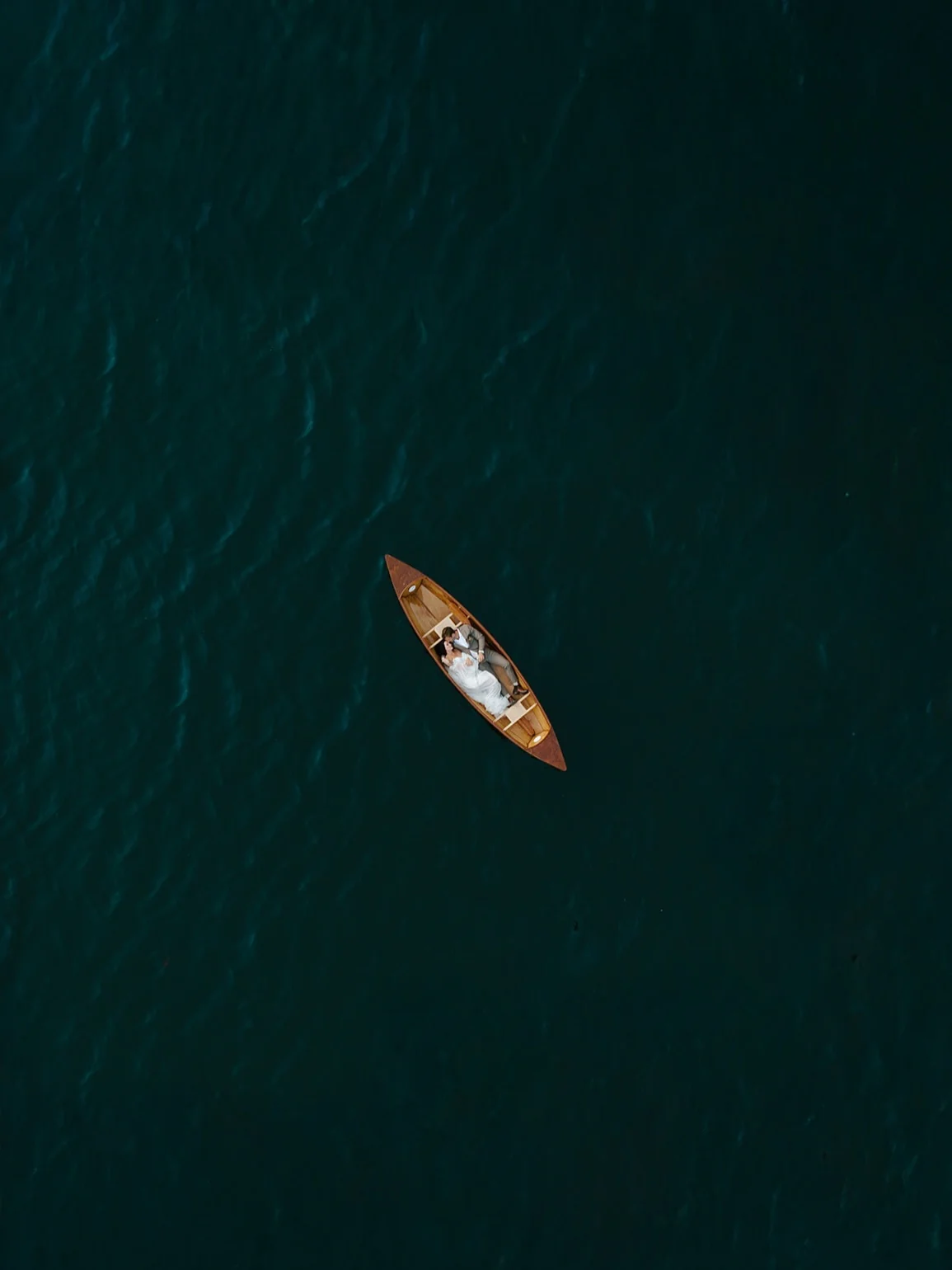 A couple in a wooden rowboat on the lake at Zaca Lake, seen from directly above
